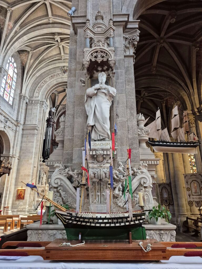 An ex-voto sailing ship rests beneath the statue of Saint Joachim