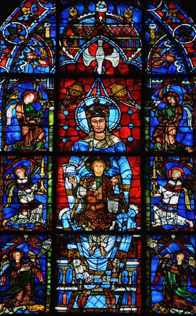 12th-century 'Notre-Dame de la Belle Verrière' stained glass window at Chartres Cathedral. The central panel shows the Virgin Mary in a brilliant cobalt blue robe, seated on a throne as the Seat of Wisdom, holding the Christ Child on her lap against a ruby-red background.